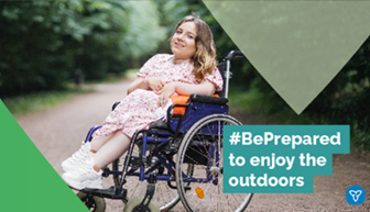 Woman with spinal muscular atrophy, sitting in a wheelchair, posing on a hiking path with green folliage lining the path. The text reads: #BePrepared to enjoy the outdoors.